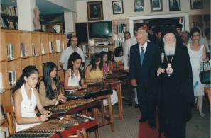 Ο Οικουμενικός Πατριάρχης Βαρθολομαίος Α΄ και ο Πρόεδρος της Ελληνικής Δημοκρατίας Κάρολος Παπούλιας στο Αναγνωστήριο (15-8-2006). Υπό τους ήχους των σαντουριών (Σταυρούλα Βεγιάζη, Μαρία Κουταλέλη, Βάσω Καλέλη, Μυρσίνη Μαγλογιάννη, Ελένη Δαγέλη, (;), Ισίδωρος Παπαγεωργίου). Διακρίνονται ακόμα οι Κώστας Ζαφειρίου, Χρύσανθος Χατζηπαναγιώτης (τότε δήμαρχος Αγιάσου), Ιάκωβος Φραντζής (μητροπολίτης Μυτιλήνης), Λευτέρης Καμπιρέλης. 