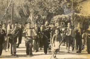 Κομπανία περιφέρεται στο χωριό παίζοντας εμβατήρια (28-10-1954).